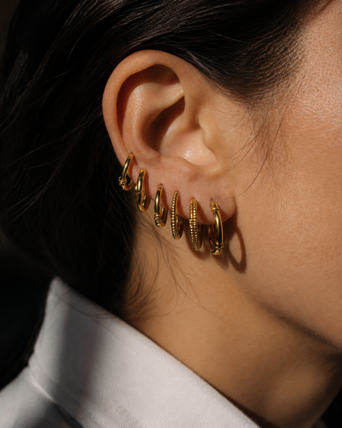 Close-up of a gold-tone hoop earring stack